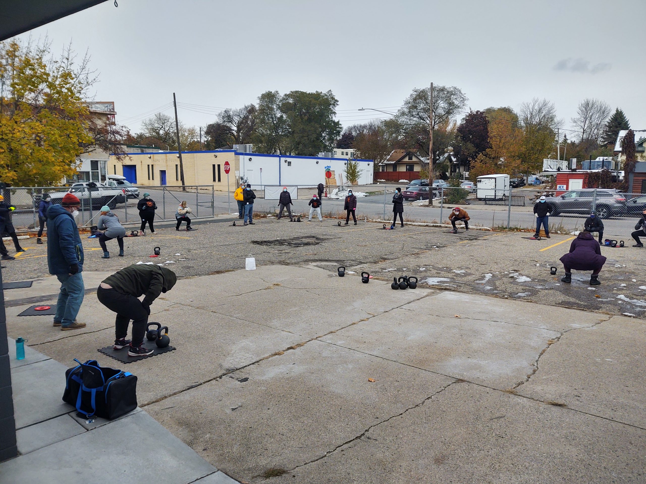 People stand, socially distanced from each other, outside on the property at Frost Iron Training.